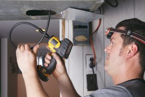 tech inspecting ductwork