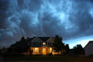 Lights shining in front of a home on a dark Halloween night.